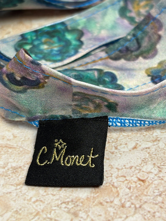 Close-up of a Monet label on a decorative item with floral patterns.