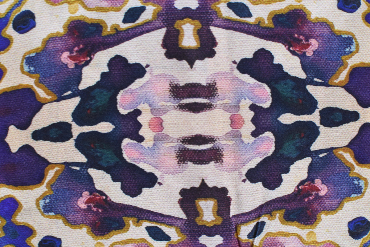 Close-up of a fabric with a colorful abstract pattern featuring purple, blue, and pink colors.