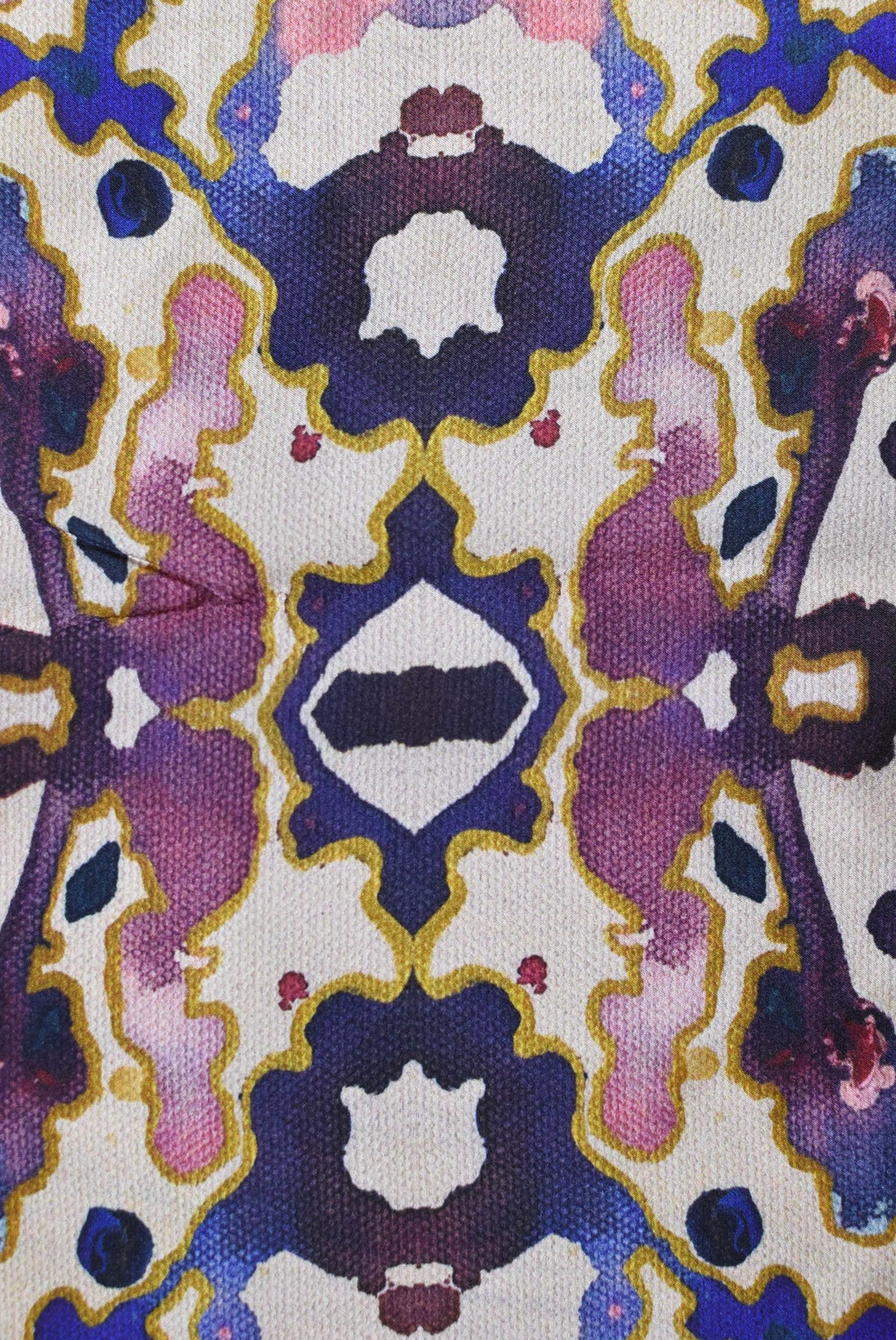 Close-up of a fabric with a colorful, patterned design featuring purple, blue, and pink colors.