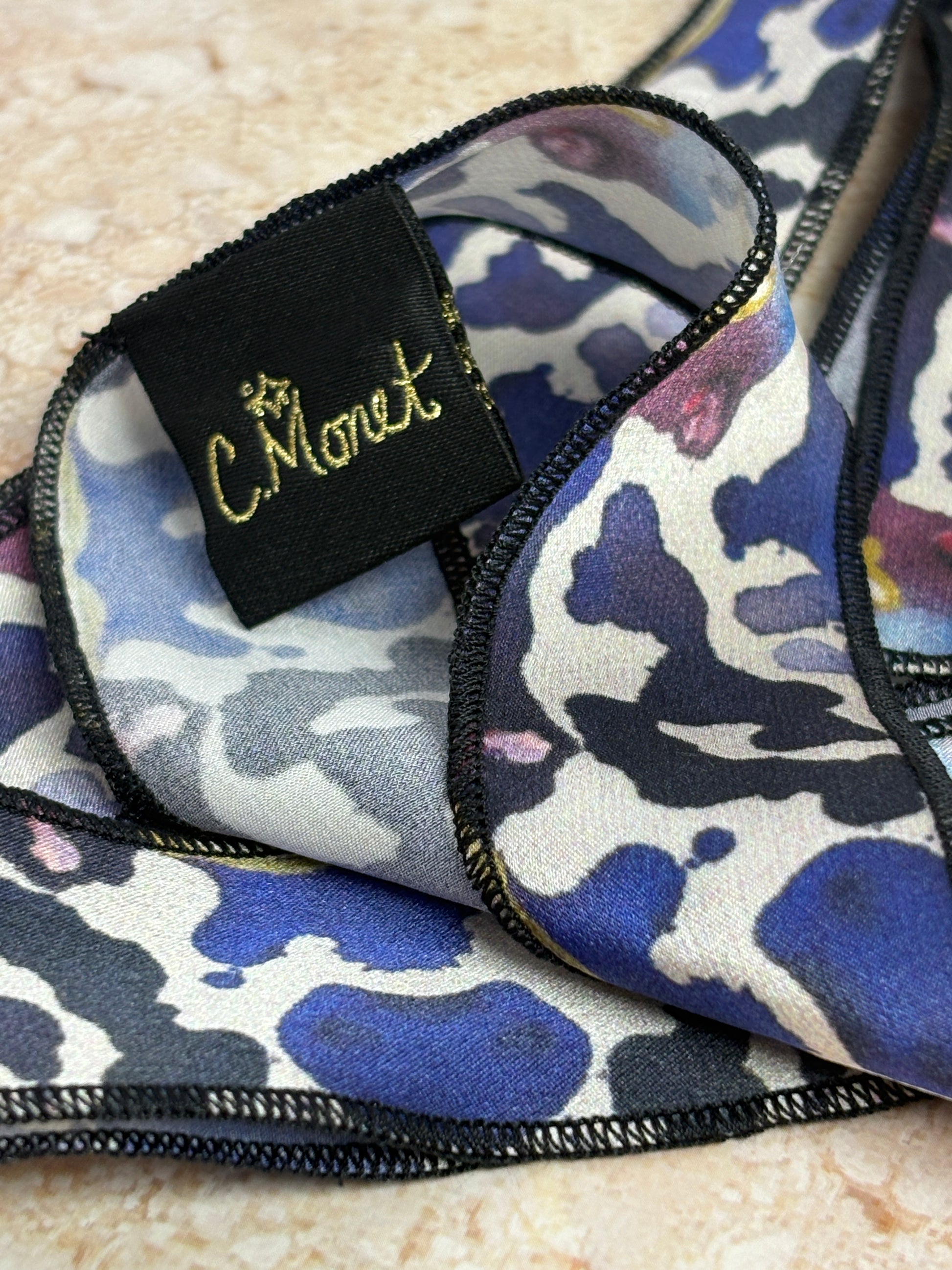 Close-up of a patterned fabric with a brand label on a textured surface