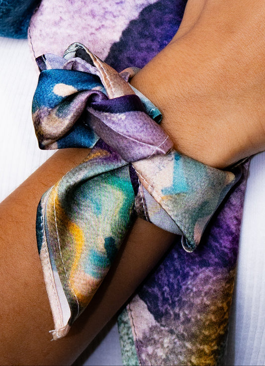 Colorful fabric bow on a person's wrist with a blurred background