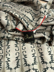 Textured fabric with black text pattern and a visible brand tag.
