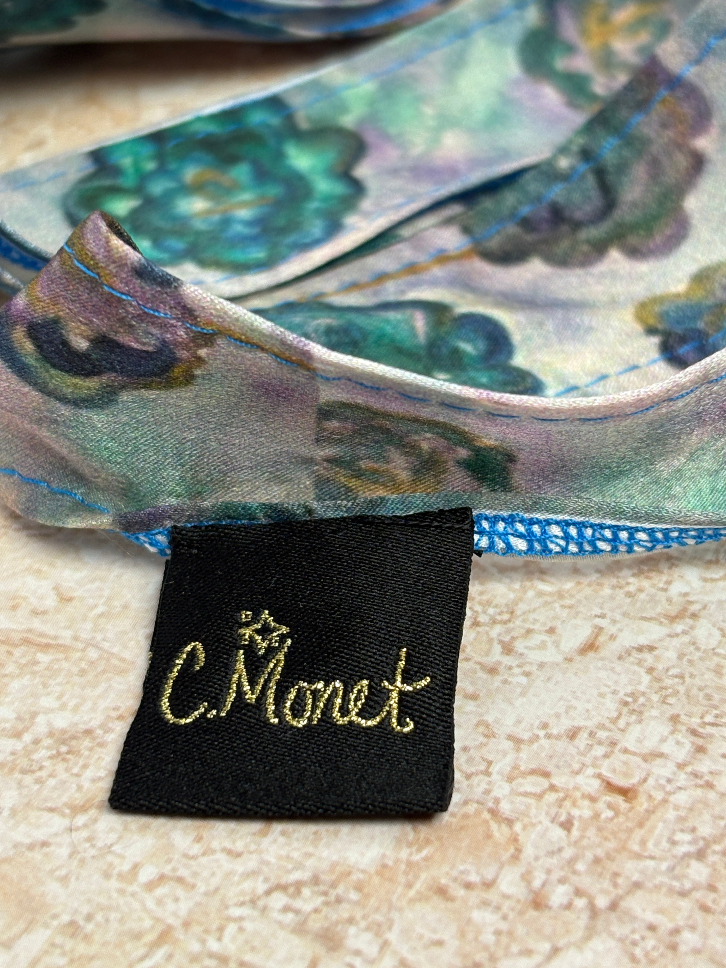 Close-up of a Monet label on a decorative item with floral patterns.