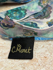 Close-up of a Monet label on a decorative item with floral patterns.
