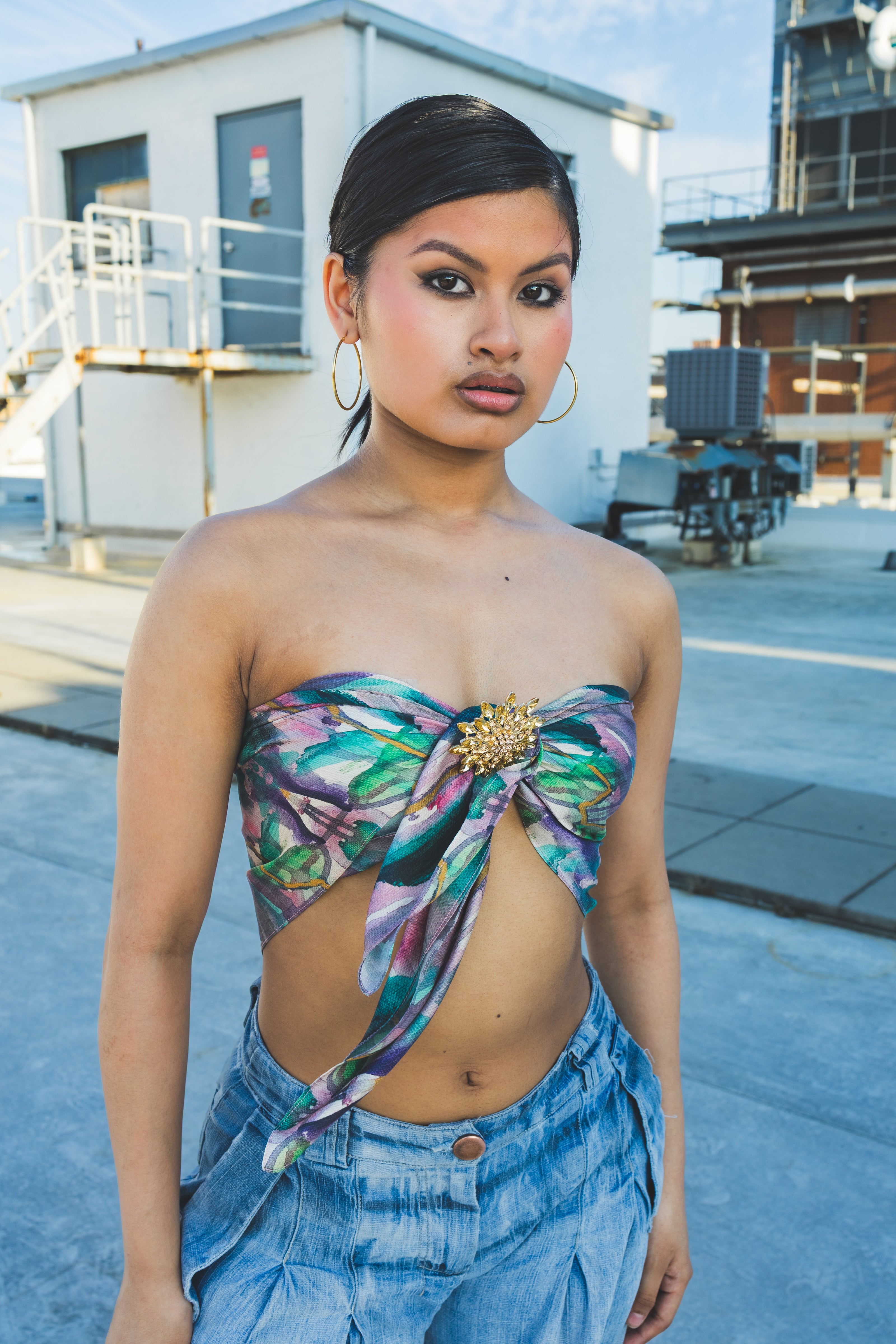 Woman wearing a floral top and denim pants in an urban setting