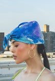 Woman wearing a blue and purple patterned headscarf 