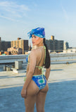 Woman in a colorful swimsuit and headscarf on a rooftop