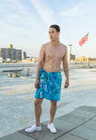 Man standing on a rooftop wearing a blue towel