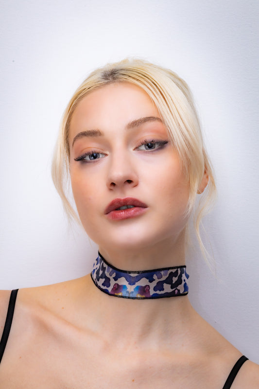 Woman wearing a colorful choker against a white background
