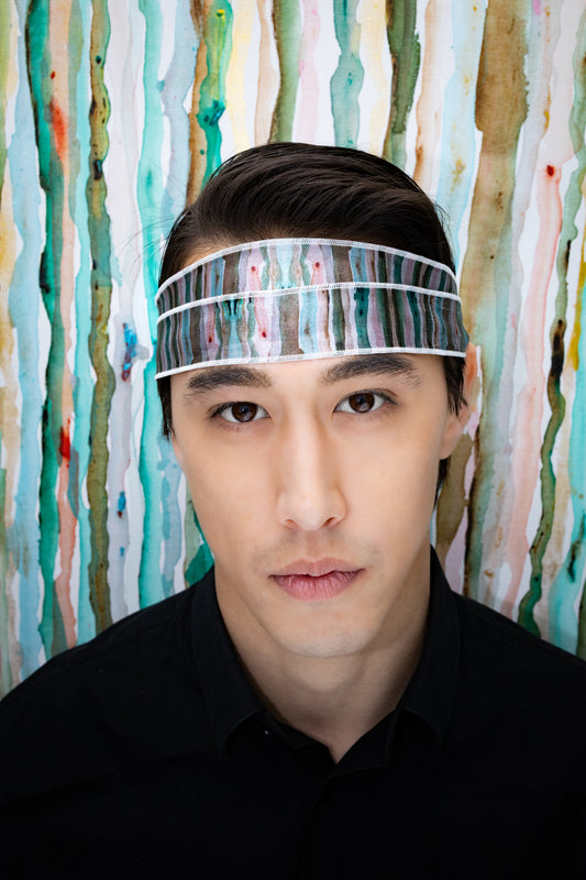 Man wearing a headband with a colorful abstract background