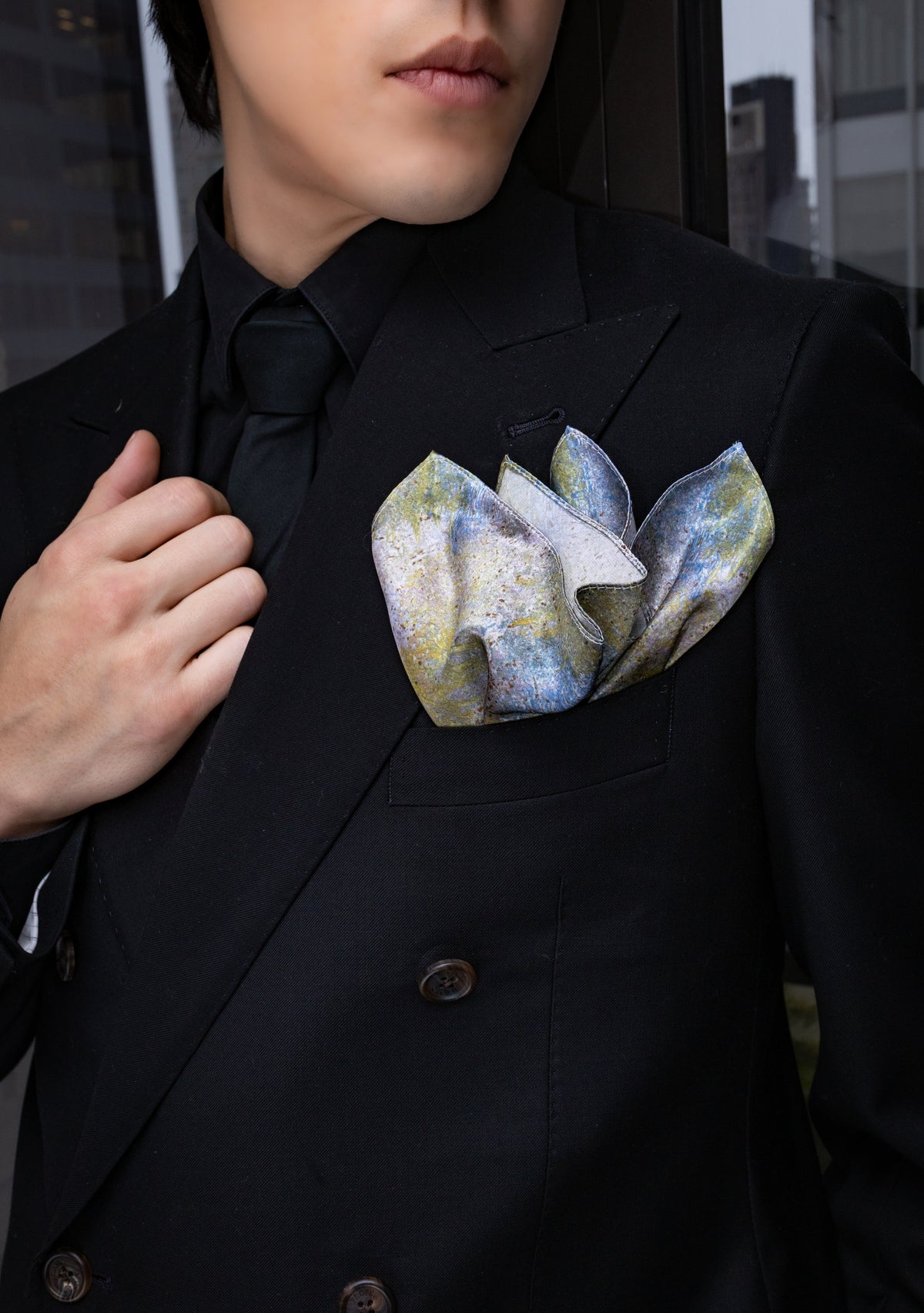 Person wearing a black suit with a floral pocket square