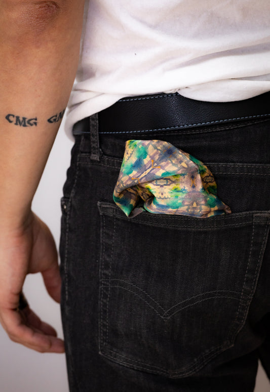 Person wearing black pants with a colorful pocket square in the back pocket.