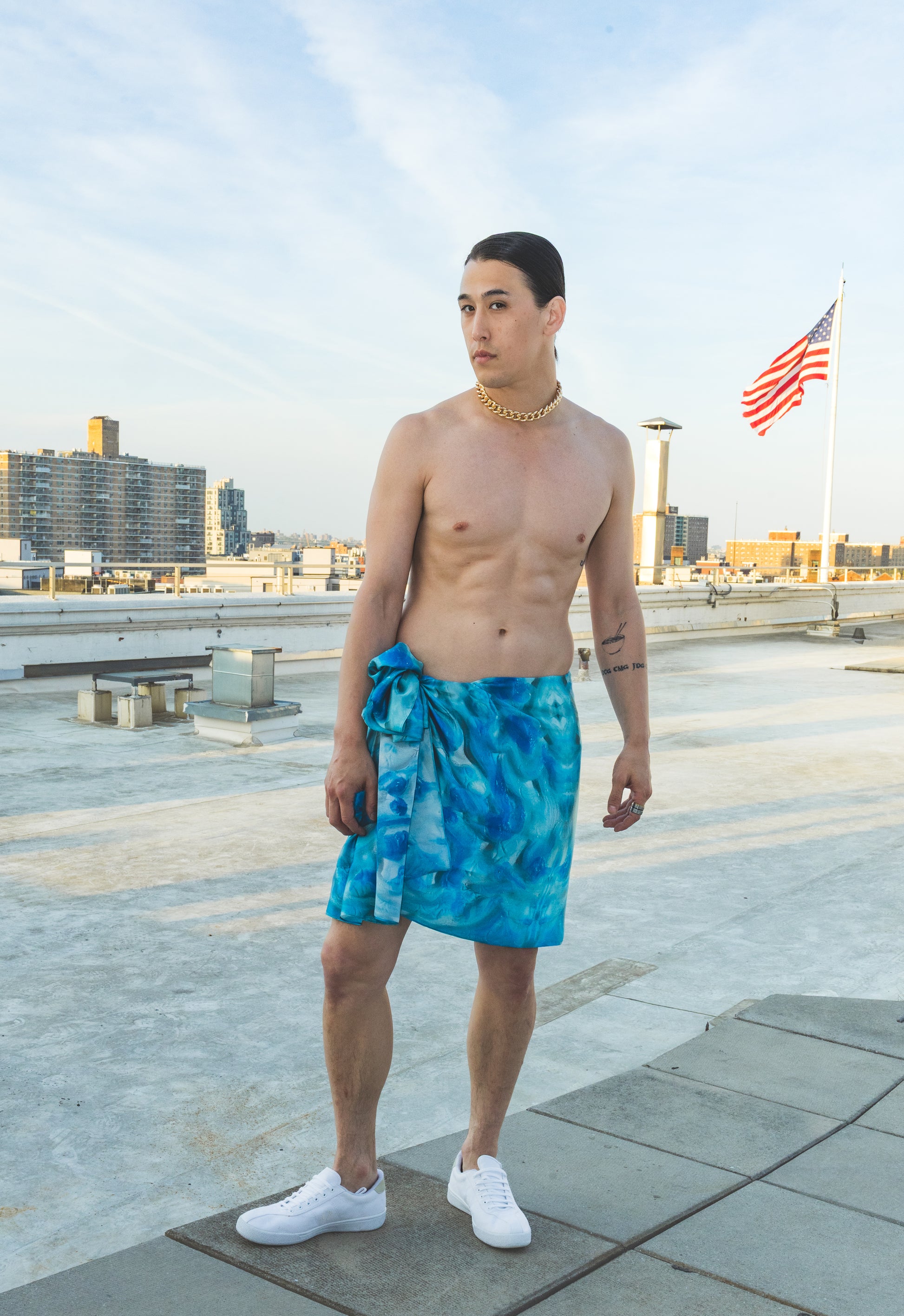 Man standing on a rooftop wearing a blue towel