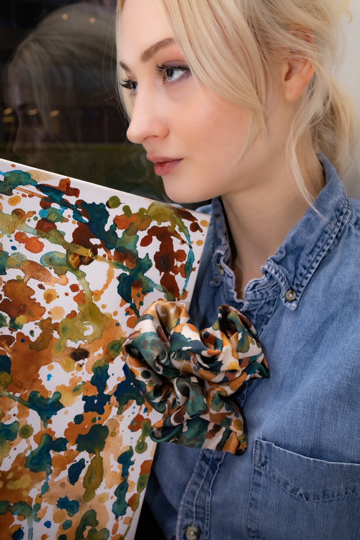 Woman holding a colorful floral pillow with a blurred background