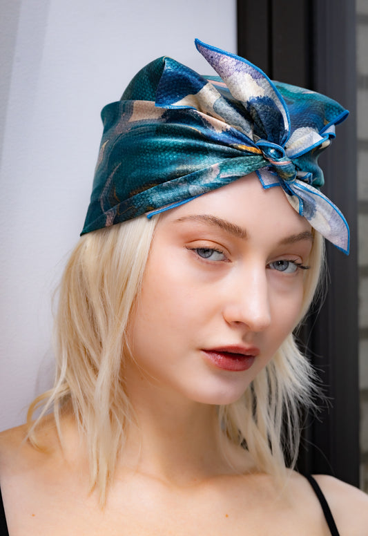 Woman wearing a blue patterned headscarf with a blurred background