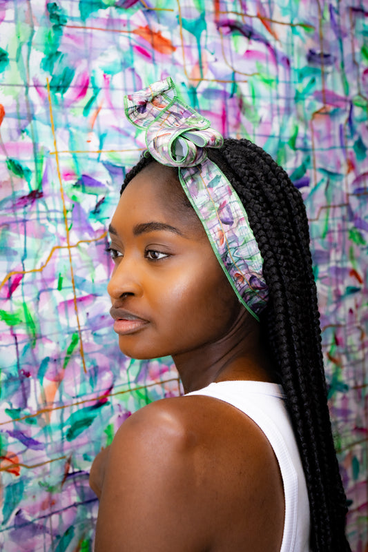 Woman wearing a colorful headscarf with a multicolored abstract background