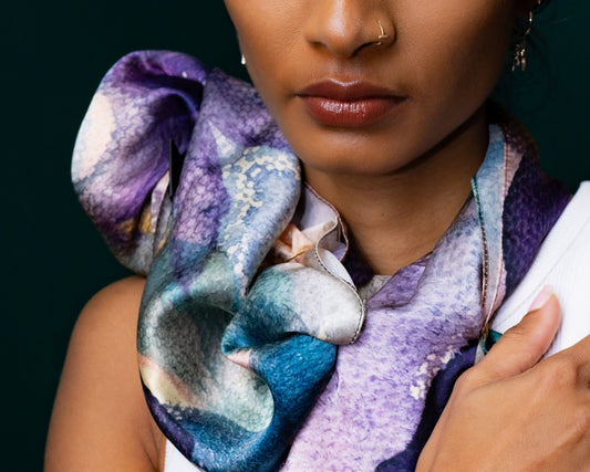 Woman wearing a colorful scarf with a dark background