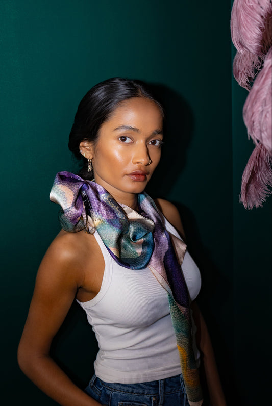 Woman wearing a colorful scarf with a dark green background