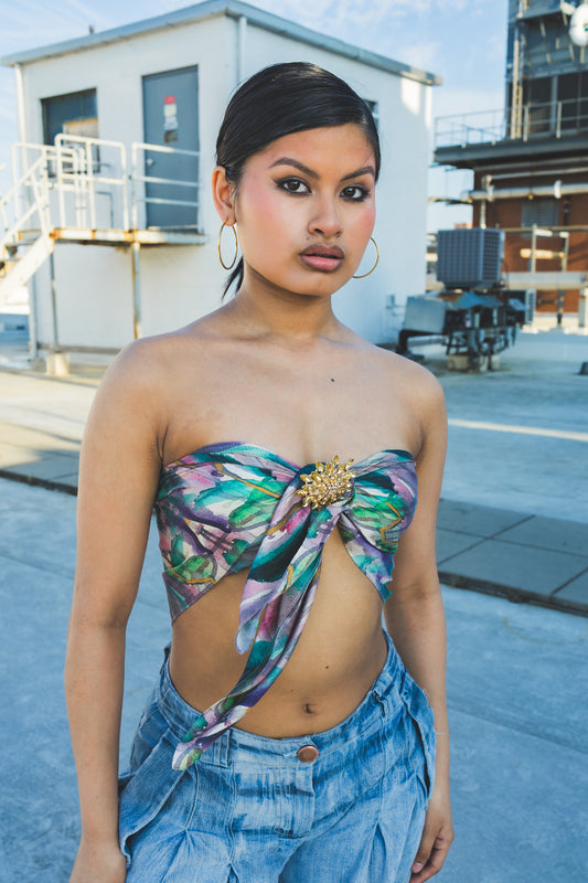 Woman wearing a floral top and denim pants in an urban setting