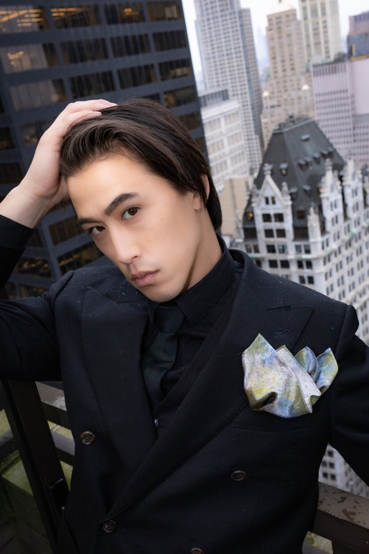 Man in a black coat with a cityscape background