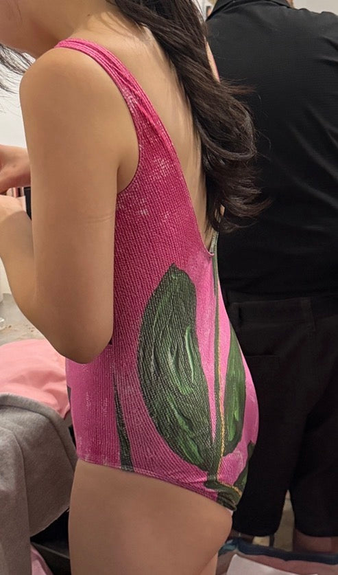 Side view close-up of a pink floral bathing suit with a green leaf print on a one piece swimsuit, by C. Monet Atelier