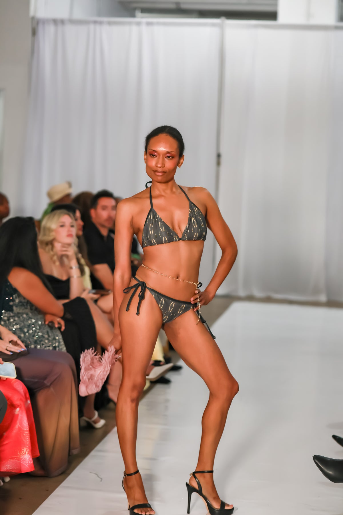 Full-length front view of low rise bikini bottoms with tie sides, paired with a matching halter top on the C. Monet Atelier runway