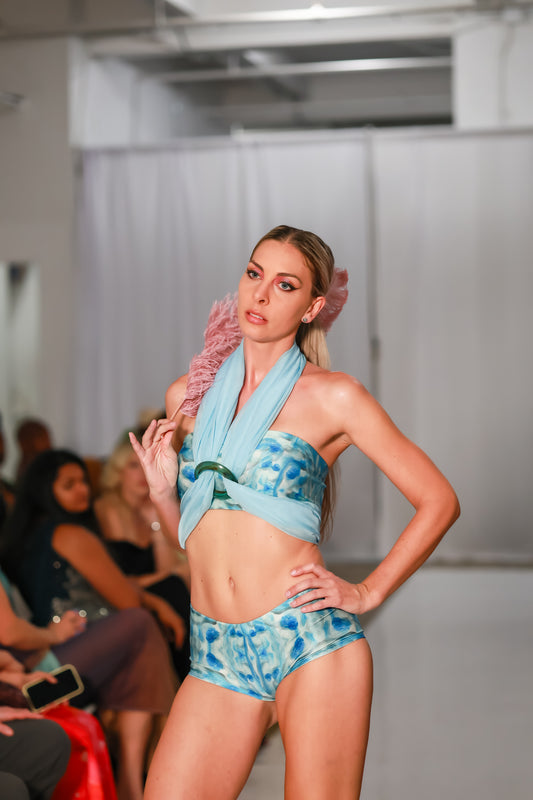 Model wearing Sky Blue swim shorts for women with matching bandeau top on runway